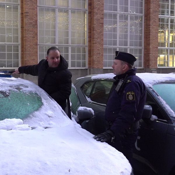 Person skrapar bilen i sällskap med polis