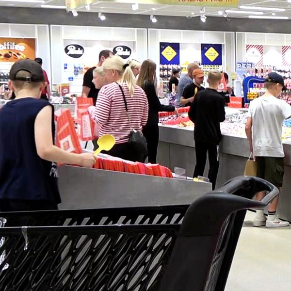 Till vänster butikschef Maarit Nyman-Pitkänen och till höger flera kunder som plockar godis.