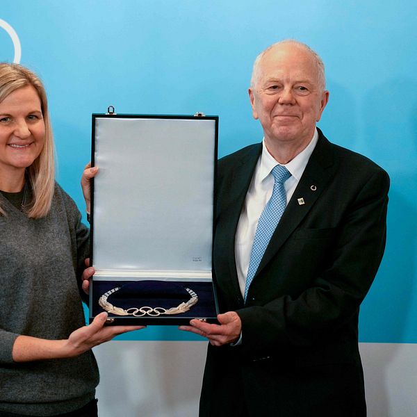Olle Dahlin får Olympic Order-utmärkelsen vid en ceremoni framför OS-ringarna.