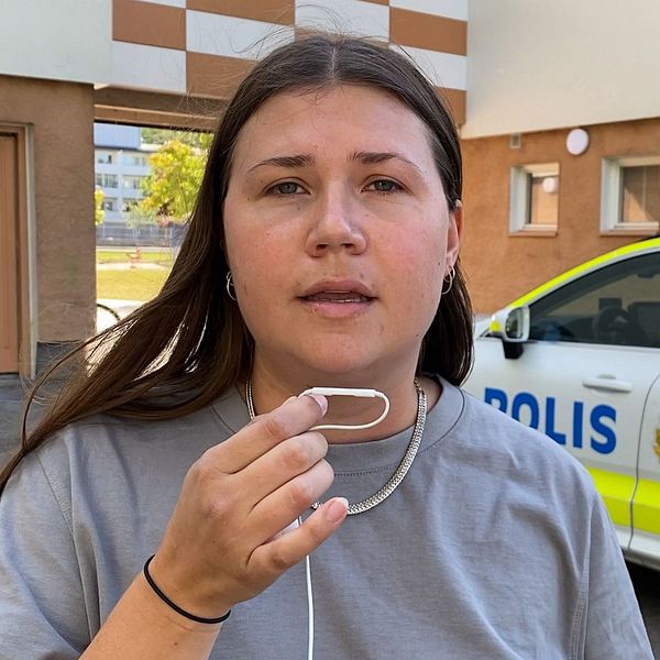 Polisband och reporter framför avspärrning efter en skottlossning i Eskilstuna.
