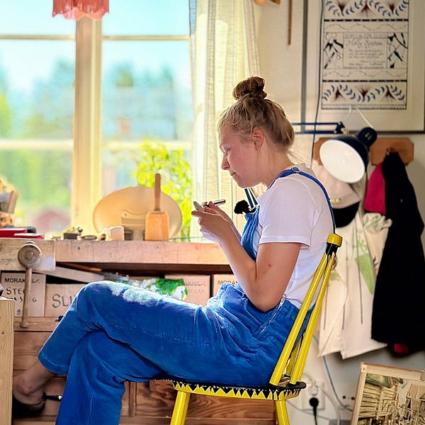 Slöjdaren Molly Sjöstam sitter i sitt rätta element och täljer.