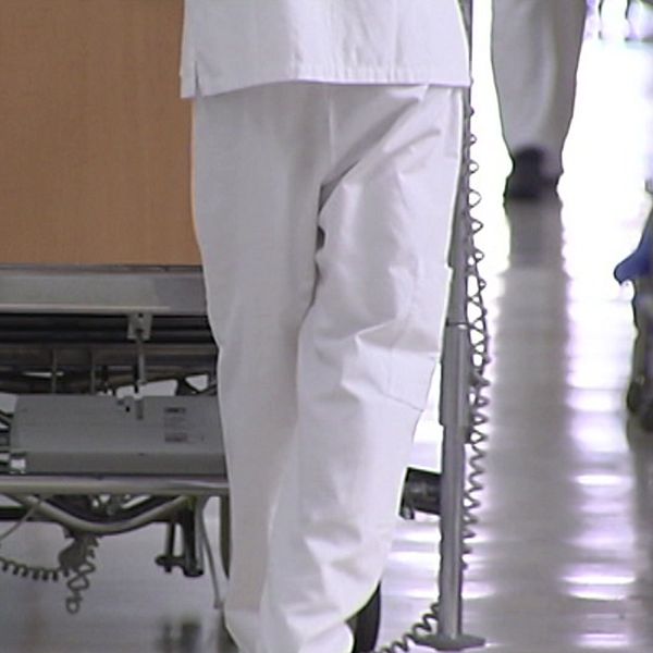 En sjuksköterska som går med en sjukhussäng.