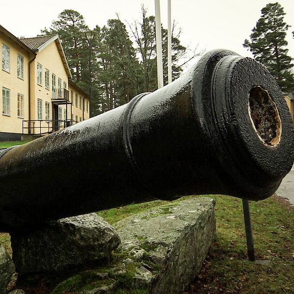 En bild på en kanon som står utanför ett gult hus på A9 i Kristinehamn.