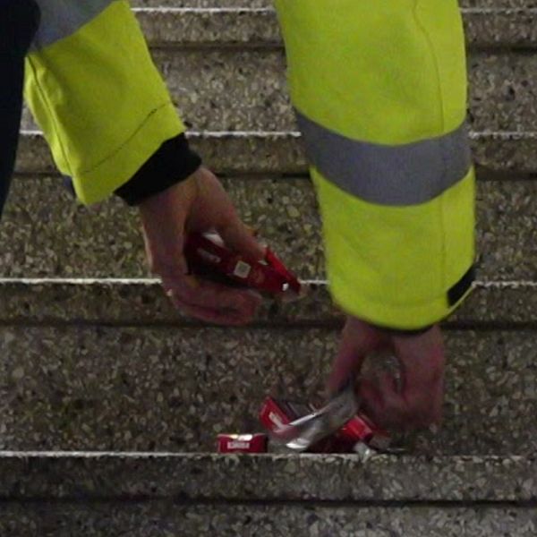tvådelad bild. Till vänster står en man med glasögon och pratar in i en mikrofon. Till höger syns trappsteg och någon som plockar upp flera cigarettpaket från dem.