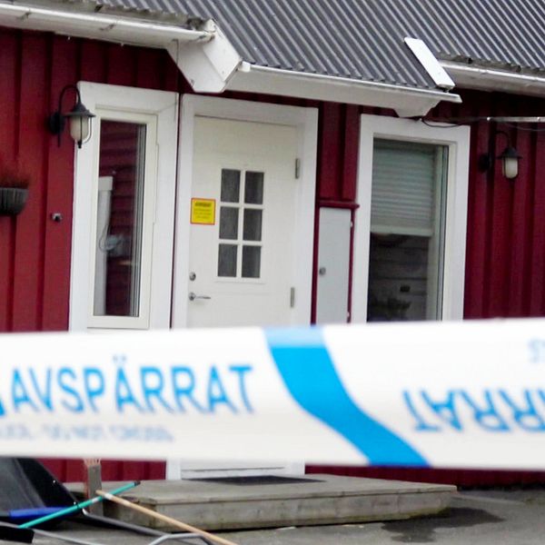 Röd villa med avspärrningsband från polisen framför ingången.