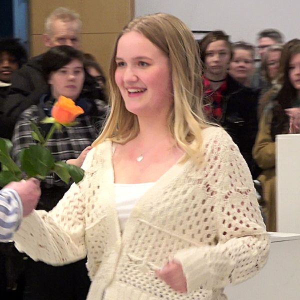 Ellen Andersson från Boden tar emot en blomma för sitt konstverk.