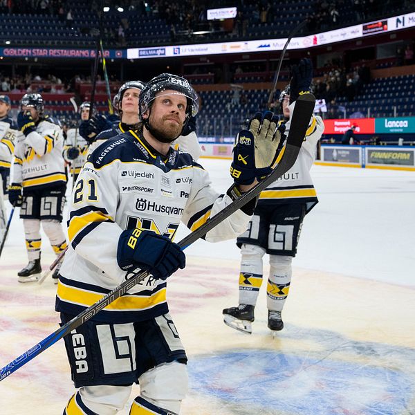 Ishockeyspelare lämnar isen efter match i en stor arena.