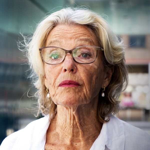 kvinna med glasögon med livlig stad i bakgrunden