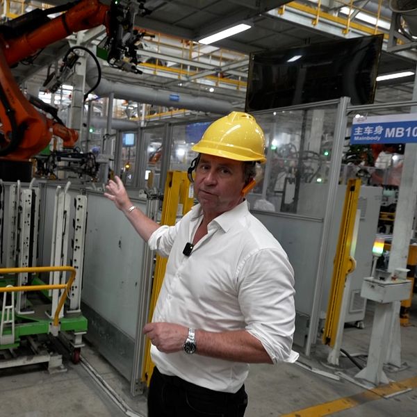 SVT-team i kinesisk elbilsfabrik med robotarm och fabriksarbetare