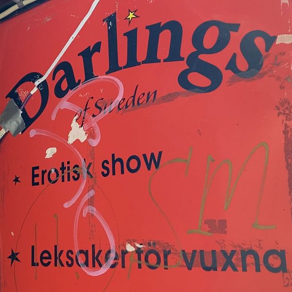Till vänster står kommunpolisen Henrik Blusi – Till höger ser du en skylt där det står Darlings som är namnet på strippklubben i centrala Sundsvall.