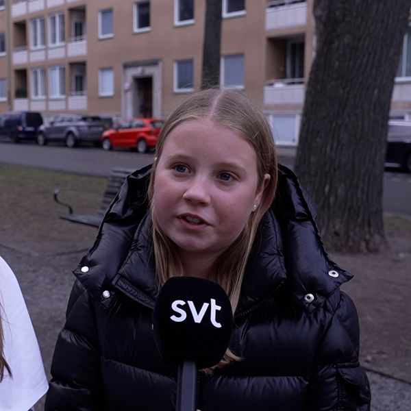 Två personer intervjuas på en parkväg, SVT-mikrofon synlig framför den ena.