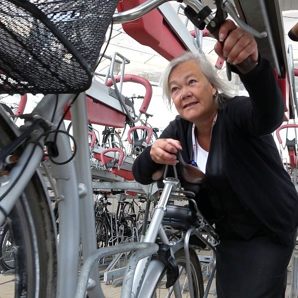Kvinna parkerar cykeln i det nya cykelgaraget