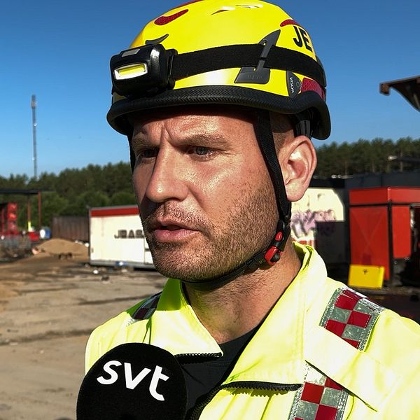 Brandman intervjuas framför brandhärd