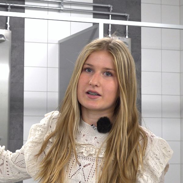 Ebba Hellstrand, elev på Lagaholmsskolan, visar de nya duschbåsen.