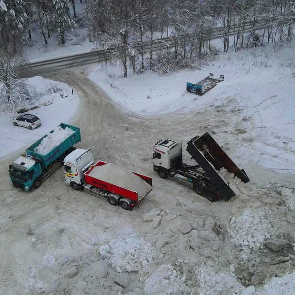 Västerås stads ingenjör på en snöhög. Lastbilar som dumpar snö.