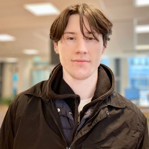 Delad bild med två personer inomhusmiljö, båda med ansikten täckta, på vänster sida syns en person med långt hår och beige tröja medan på höger sida en person med kort hår och mörk klädsel.