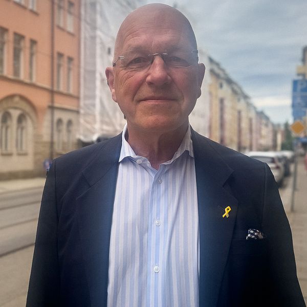 Christopher Jarnvall (SD) står utomhus i Norrköping vid ett möte om återvandring
