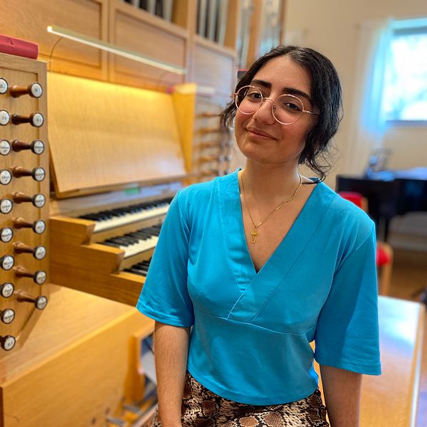Ung kvinna framför en orgel, när hon ska prata om bristen på kyrkomusiker inom Svenska kyrkan