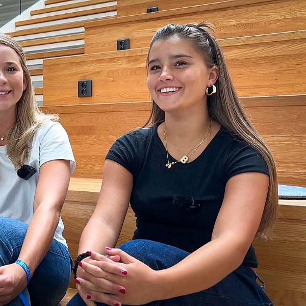 Izabella Envall och Henriette Rogstad sitter på en trätrappa inför studiestart i Halmstad.