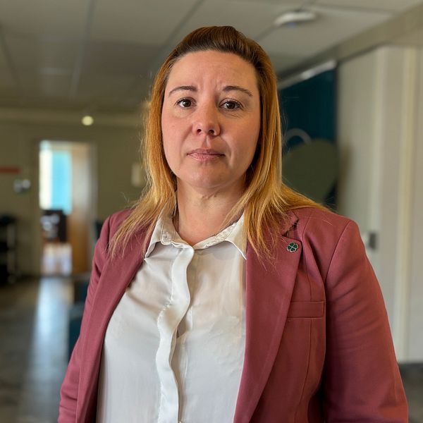Planritningar och en kvinna i röd jacka, kommunalrådet Annie Östlund (C), ansvarig för Huddinge kommuns bygglovsfrågor
