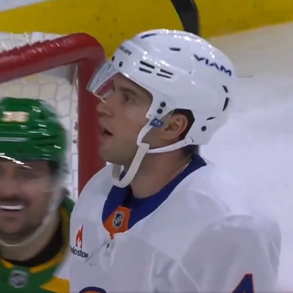 New York Islanders back Tony Deangelo ser förbluffad ut i sin vita ishockeyhjälm. Bakom honom firar Mats Zuccarello i sin gröna hjälm.