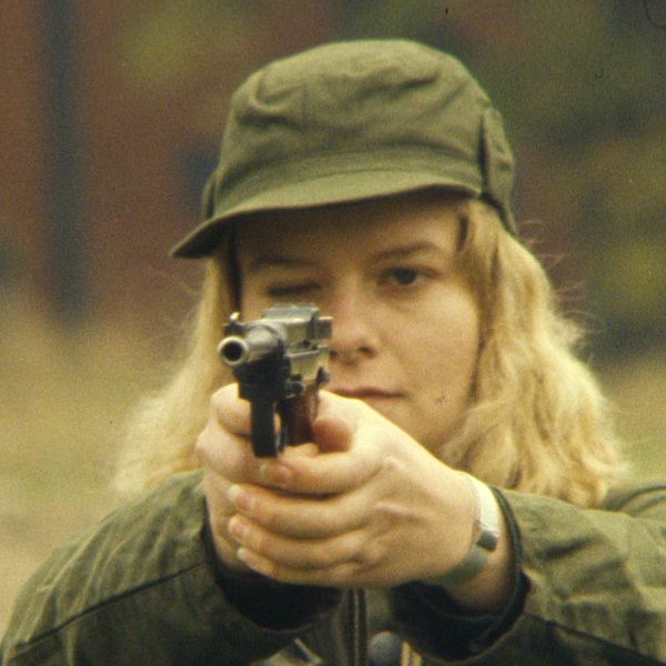 Tvådelad bild. Vänster: Skylt på Curmanska magasinets vägg i Gamla Linköping. Höger: Ung kvinna i militärgrön keps som siktar med pistol.