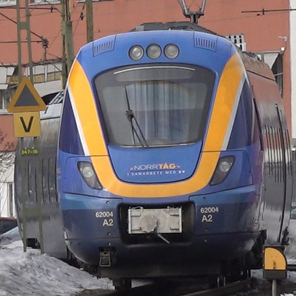 En exteriörbild på tågstationen centralen i Sundsvall i mars 2024 och till höger ett blått tåg lok från Norrtåg