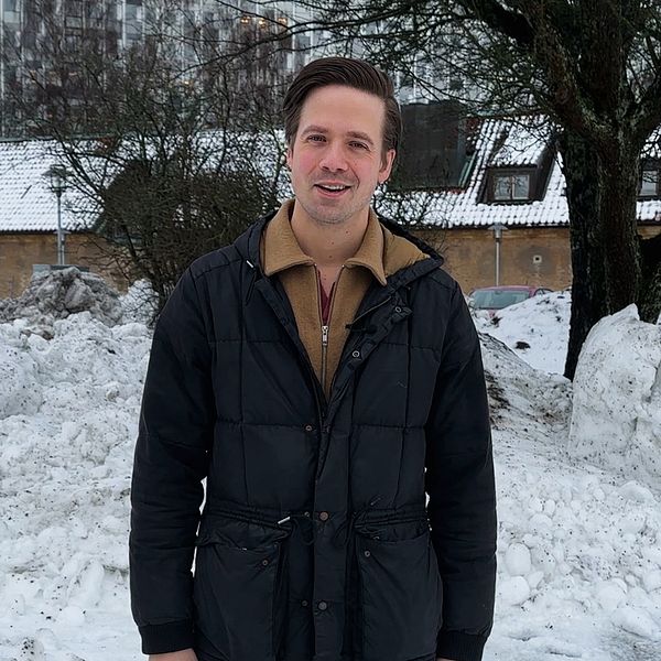 Ett fyrverkeri i skyn. Man ser även en julgran och en person med en fluffig jacka