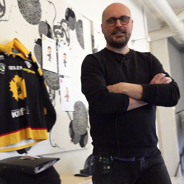 Bilden är delad i två sektioner. I den vänstra sektionen pekar en person på en datorskärm som visar ett ishockeyspel, medan två andra personer sitter vid samma bord och arbetar. I den högra sektionen visas en hockeytröja hängande på en vägg bredvid några teckningar och illustrationer. En person står bredvid med armarna i kors.
