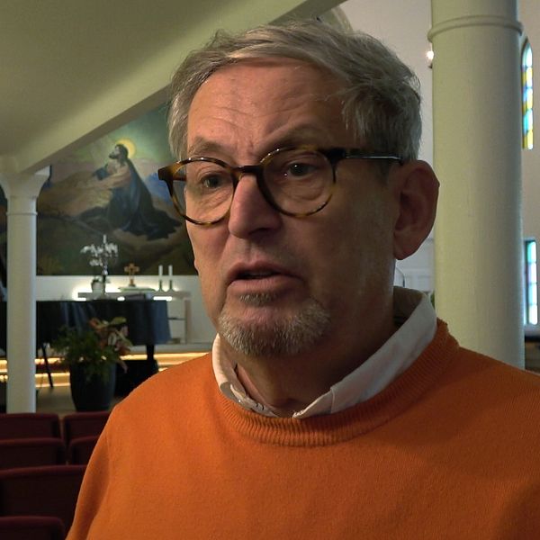 En delad bild med två sektioner. Den vänstra delen visar en inredning av en kyrka med en stor väggmålning som föreställer en religiös scen med Jesus, medan den högra delen visar en man i en orange tröja, Mats Arebäck som är ordförande i församlingen.