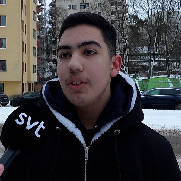 Person som mönstrar och ung kille i utomhusmiljö med svart jacka och mörkt hår.