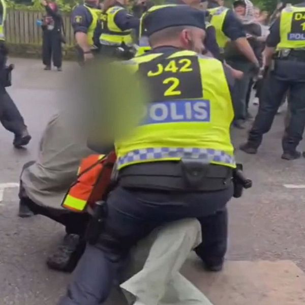 en polisman och en polis som håller fast en demonstrant