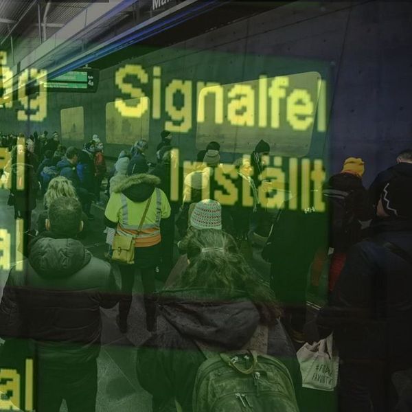 Tågtavla med inställda avgångar och folkmassa på tågstation.