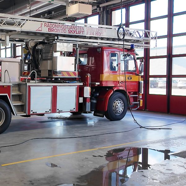 Brandbil med stege står inne i en brandstation.