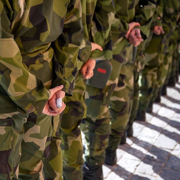 Delad bild: Till vänster syns en person klädd i mörka kläder med en mikrofon fäst på bröstet, medan höger sida visar en rad personer i svensk militäruniform med händerna knäppta.