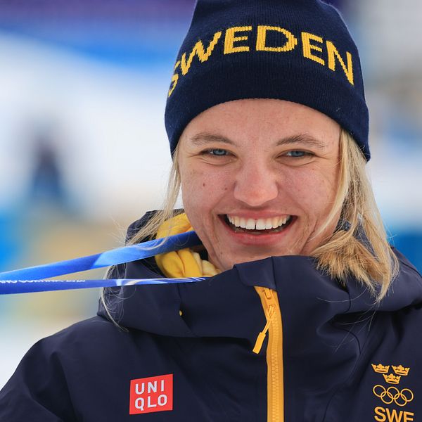 Linn Svahn med guldmedalj och svensk mössa i skidmiljö