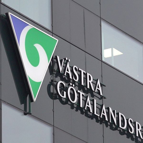 En delad bild med två sektioner: till vänster en person i en beige skjorta med en mikrofon fäst vid bröstet står i en kontorsmiljö; till höger en vägg med Västra Götalandsregionens logotyp och text.
