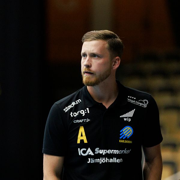 Handbollsspelare i svart tröja och nummer 17 i gul tröja på spelplanen.