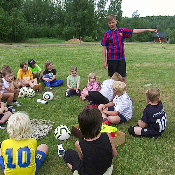 Barn på fotbollsplan och reporter Karin Mannberg