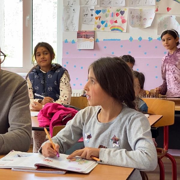 Reporter Peter Nässén sitter i skolbänken bredvid en 10-årig romsk flicka. Hon medverkar i det skolprojekt som Hoppets stjärna driver i Rumänien.
