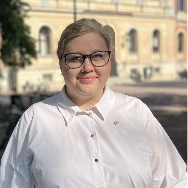 Kvinna framför träd och cyklar