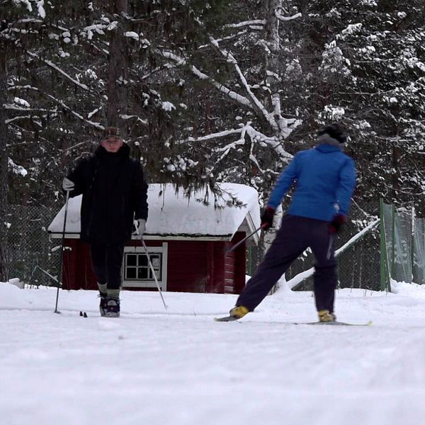 Pistmaskinförare och längdskidåkare ute i spåren till höger.