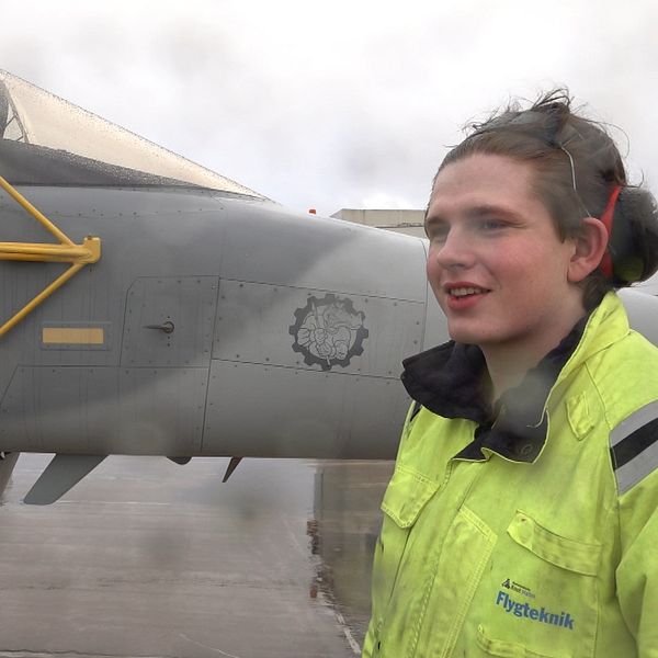 Ung man bredvid en JAS-Gripen