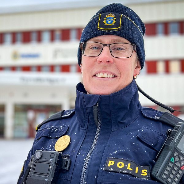 Trafikpolis står i gull mundering utanför polisstationen i Östersund och ler in i kameran.