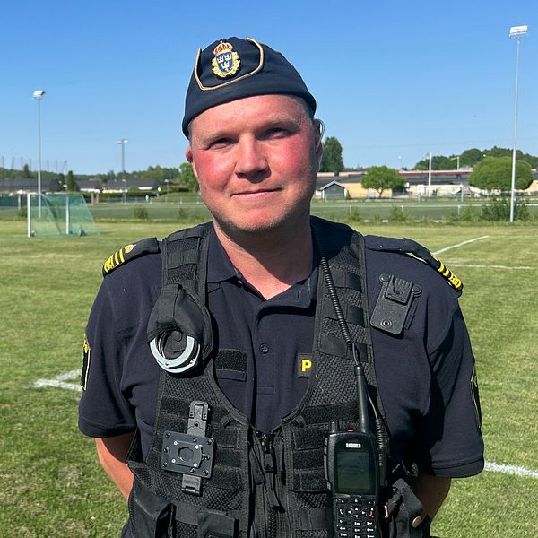 En polis som står på en fotbollsplan.