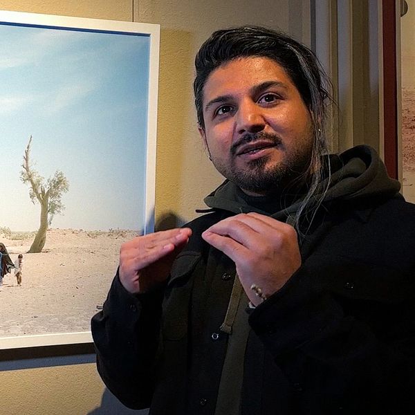 Fotografen Hashem Shakeri visar en av sina bilder från utställningen