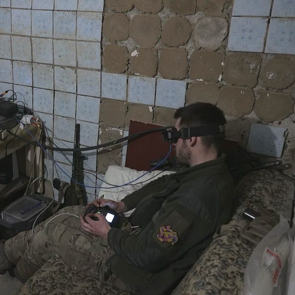 Två unga ukrainska män sitter i ett rum med teknisk utrustning, från vilket de styr drönare i kriget.