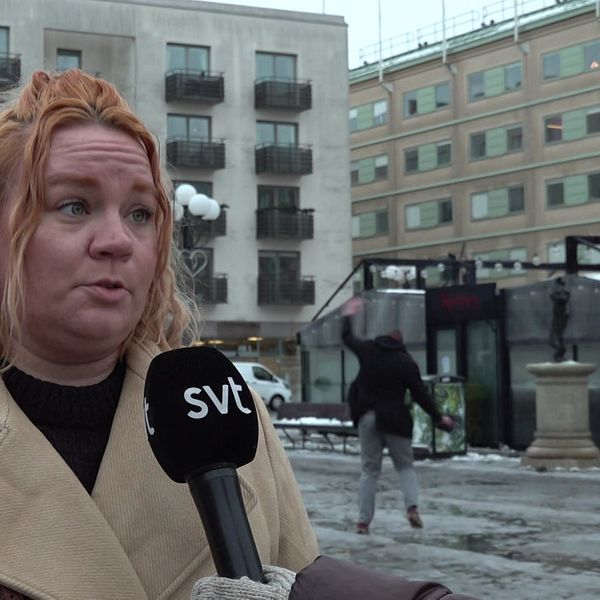 Person halkar i bakgrunden under en intervju.