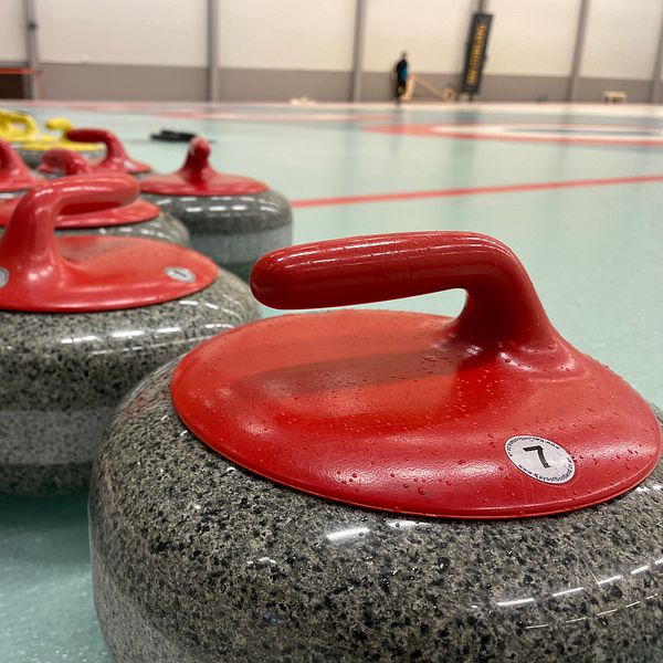 Röda curlingstenar på rad.