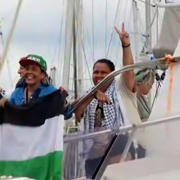 Lorena Delgado Varas på båt med palestinsk och malaysisk flagga inför resa mot Gaza.